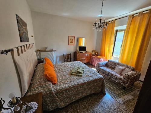 uma sala de estar com uma cama e uma cadeira em a casa di Gabri em Montefollonico