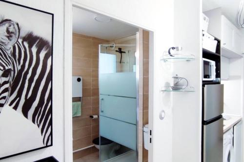 une salle de bains avec une photo zébrée sur le mur. dans l'établissement RAVAS Studio climatisé terrasse proche commerces, à Montpellier