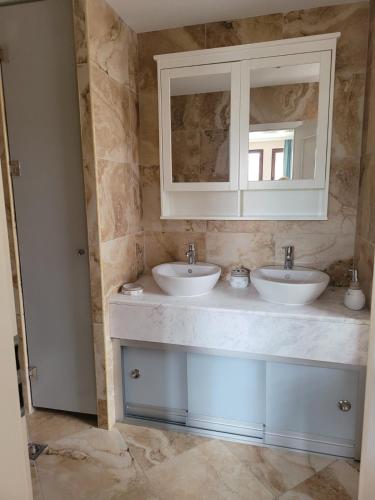 a bathroom with two sinks and a mirror at Green Line Villa Sozopol in Sozopol