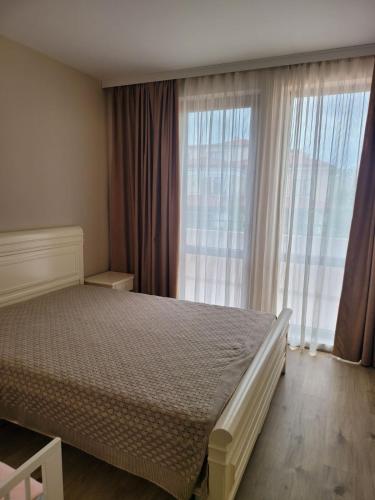 a bedroom with a bed and a large window at Green Line Villa Sozopol in Sozopol