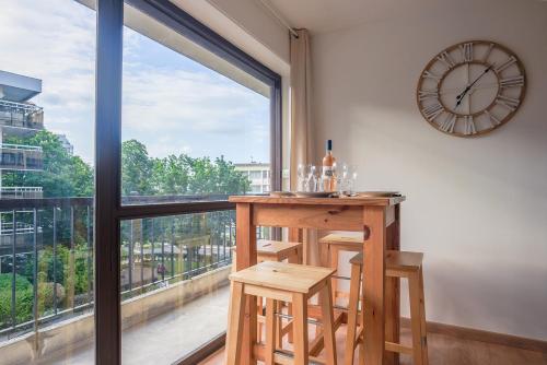 une chambre avec une table, une horloge et une fenêtre dans l'établissement Cham's House - T2 Chamalières, à Chamalières