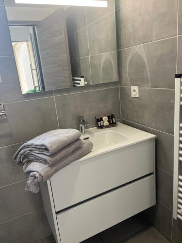 bagno con lavandino bianco e specchio di Résidence Arborea C3 Corte a Corte