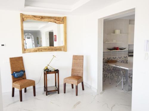 マルベーリャにあるVilla Marbellaの椅子2脚、鏡付きテーブルが備わる客室です。
