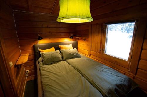 a bedroom with a bed in a room with a window at Log Cabin, forrest , sea view, north Sweden. in Luleå