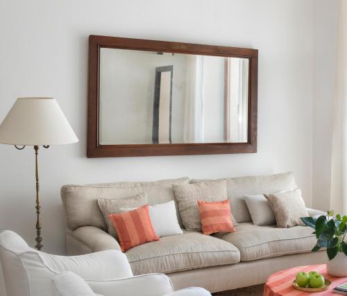 a living room with a couch and a mirror at Ca'n Puig de Sòller in Sóller