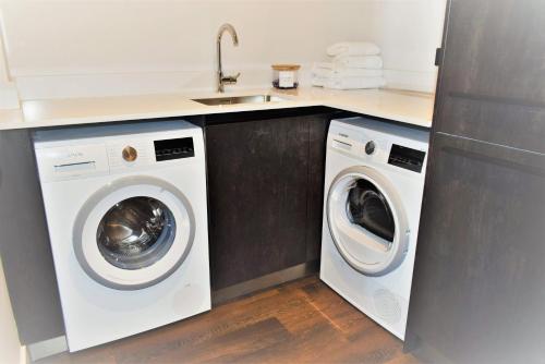 a kitchen with two washing machines and a sink at 17 The Fairways in Broadstairs
