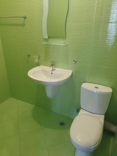a bathroom with a toilet and a sink at Стаи за гости Мистрал in Primorsko