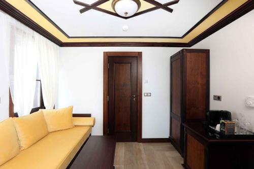 a living room with a couch and a ceiling at Armaco Residence in Koprivshtitsa