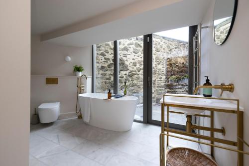 a bathroom with a tub and a toilet and a sink at JOIVY Observatory House and Apartment in Edinburgh