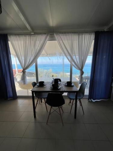 uma sala de jantar com uma mesa e cadeiras em frente a uma janela em Elia’s house em Ligia
