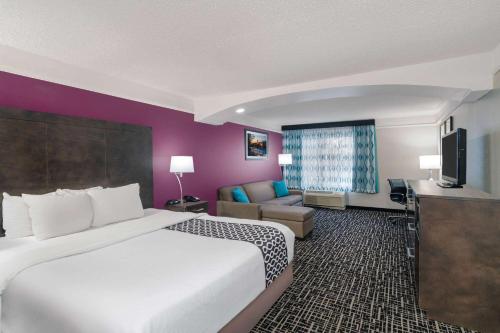 a hotel room with a large bed and a couch at La Quinta by Wyndham Latham Albany Airport in Latham