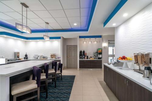 a kitchen with blue ceilings and a bar with chairs at La Quinta by Wyndham Latham Albany Airport in Latham