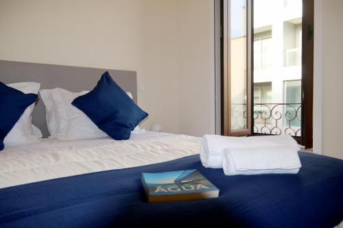 una camera da letto con un letto con un libro sopra di Cabo do Mar Apart- Azul Beach a Espinho
