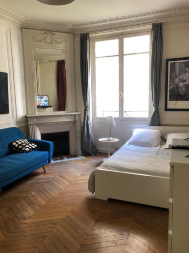 una camera con un letto e un divano blu di Studio à Paris près du Pont Mirabeau et Tour Eiffel a Parigi