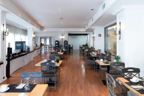 a restaurant with tables and chairs in a room at Barceló León Conde Luna in León