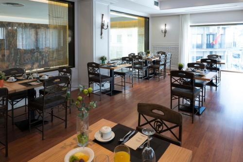 a restaurant with tables and chairs in a room at Barceló León Conde Luna in León