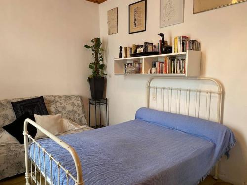 a bedroom with a bed with a blue blanket and a couch at Nice flat terrace big garden 10min beach'n'center in Argelès-sur-Mer
