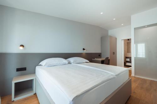 a bedroom with a large white bed with two pillows at Apartmani Stipe Brela in Brela