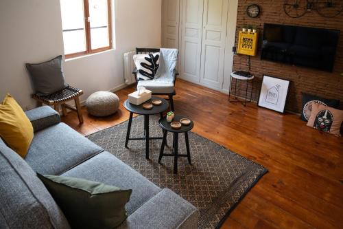a living room with a couch and two chairs at Redbrick’s Bergerac, Au coeur du centre historique in Bergerac