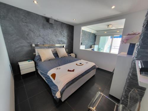 a bedroom with a bed and a mirror at LE COLOMBIER T3 VUE MER PANORAMIQUE in Antibes