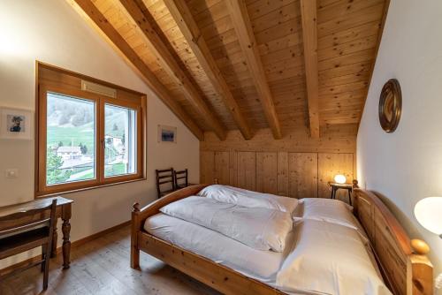 Cama en habitación con techo de madera en Chalcherin - Celerina, en Celerina