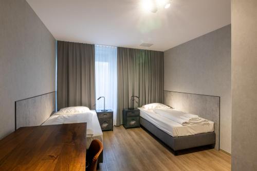 Habitación de hotel con 2 camas y mesa en mk monteurzimmer stuttgart, en Stuttgart