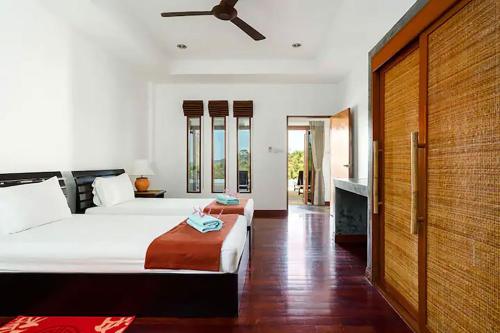 a bedroom with a bed and a ceiling fan at Villa E in Taling Ngam Beach