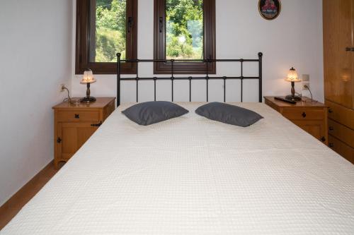 a bedroom with a large white bed with two windows at Pantheon 2 in Mouresi