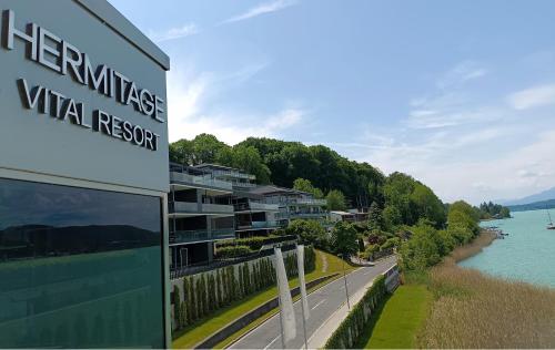 a sign for a villas virtual resort next to a river at Hermitage Wörthersee Penthouse Appartement in Maria Wörth