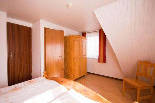 ビューズムにあるHaus-Karin-Ferienwohnung-1のベッドルーム1室(ベッド1台付)、木製キャビネットが備わります。