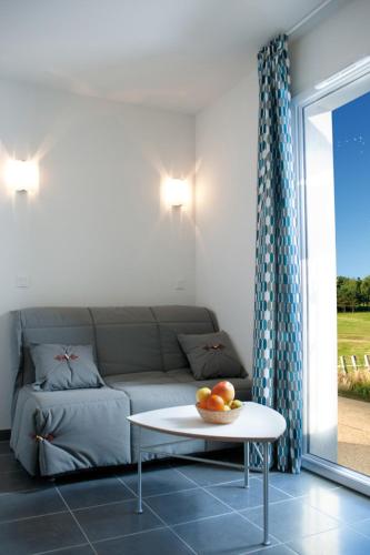 a living room with a couch and a table at Lagrange Vacances Domaine de Val Queven in Quéven