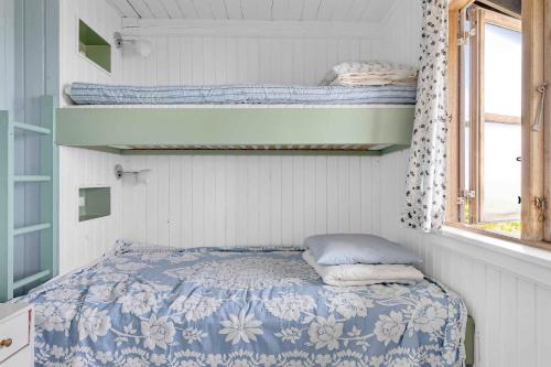 a small bedroom with a bed and two bunk beds at Summerhouse At The Beach in Rørvig