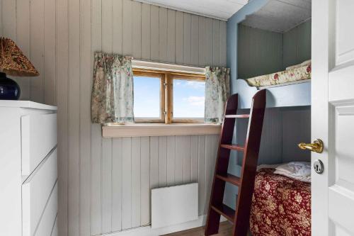 a small room with a bunk bed and a window at Summerhouse At The Beach in Rørvig
