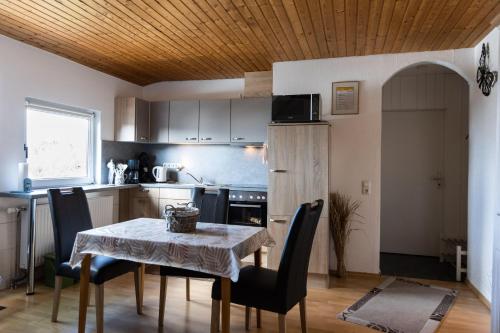 a kitchen with a table and chairs and a kitchen with a table and a table at Haus-Lily-Nr-04 in Büsum