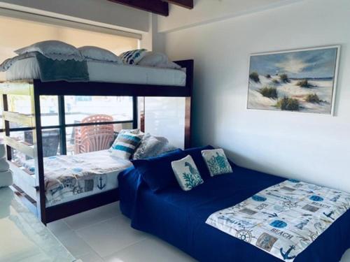 een slaapkamer met een stapelbed en een bank bij Edificio Bay Point Apto 402 Punta Hansa in San Andrés