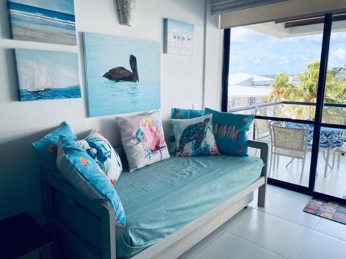 Un sofá con almohadas en una habitación con balcón. en Edificio Bay Point Apto 402 Punta Hansa, en San Andrés