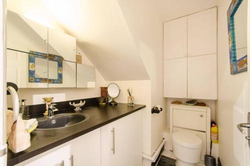 a white bathroom with a sink and a toilet at Leeward Gardens With EnSuite in London