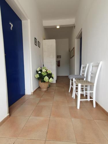 a hallway with chairs and a table and a potted plant at Babis & Popi Rooms and Studios in Frangokastello