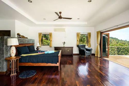 a bedroom with a bed and a ceiling fan at Villa E in Taling Ngam Beach