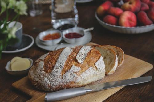 a loaf of bread on a cutting board with a knife at Henrys Townhouse Marylebone, London in London