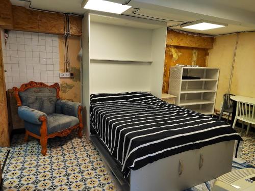 Habitación con cama y silla. en Appartement d'une chambre avec terrasse amenagee et wifi a Beziers, en Béziers