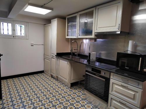 une cuisine avec des armoires blanches et des comptoirs noirs dans l'établissement Appartement moderne à Béziers avec terrasse commune - 40 m², à Béziers