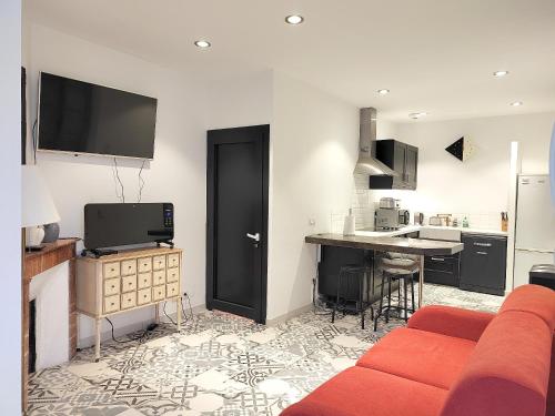 un salon avec un canapé rouge et une cuisine dans l'établissement Appartement charmant à Béziers, terrasse commune, 40 m², à Béziers