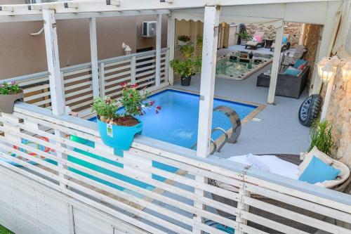 a deck with a plunge pool on a house at שקד באופק - וילה מקסימה עם 2 בריכות וג'קוזי מול החרמון in Metulla