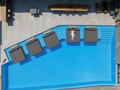 a person standing in front of a swimming pool at ​Le Grand Bleu Resort in Derveni