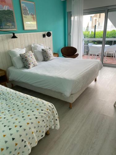 a bedroom with two beds in a room with blue walls at Hôtel Saint-Clair, côté Plage in La Grande Motte
