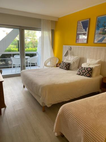 a hotel room with two beds and a balcony at Hôtel Saint-Clair, côté Plage in La Grande Motte