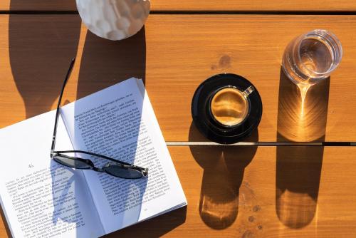 a book and a cup of coffee on a table at ​Le Grand Bleu Resort in Derveni