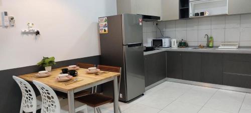 a kitchen with a wooden table and a refrigerator at New The Sun Homestay at Sg Nibong nearby Queensbay or PISA or FTZ Bayan Lepas HENG in Bayan Lepas