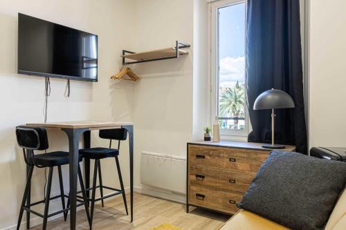 ein Wohnzimmer mit einem Schreibtisch, einem Bett und einem Fenster in der Unterkunft Sublime studio renovated - Cannes center in Cannes